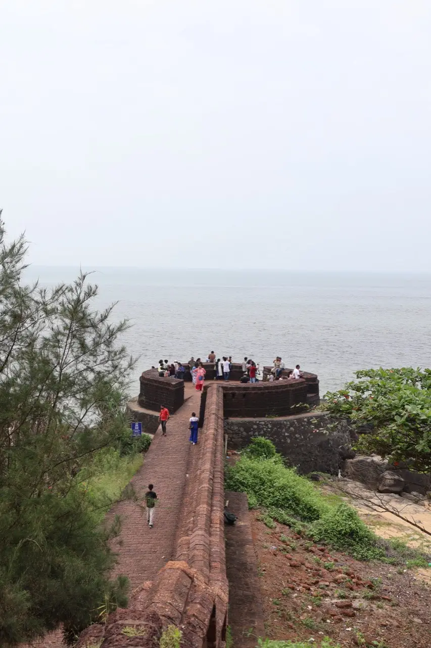 Visitors walking the laterite ramparts of Bekal Fort above the sea